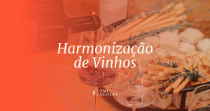 Imagem com filtro avermelhado mostrando o momento em que um vinho tinto é servido em uma taça de cristal. Ao fundo, uma tábua de petiscos com pães, grissinis e alecrim. No centro, o texto "Harmonização de Vinhos" e o logotipo da Eno Cultura abaixo.